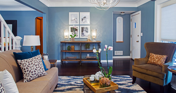 As seen on HGTV's Renovation Raiders, the Rangel's living room has been transformed into a media free oasis, which has a contemporary look with a rustic feel. There is no longer hand me down furniture, and the space has personal touches to make this now their home. The deep blue walls envoke relaxation, there are plenty of cozy elements and seating for all, even a built in ledge under the window for the cat to sit and look outside.The space is truely welcoming to entertain family and friends.  The wall has been opened up to expose the staircase which opens up the room and it flows into the dining room. (after), ( After 4 )